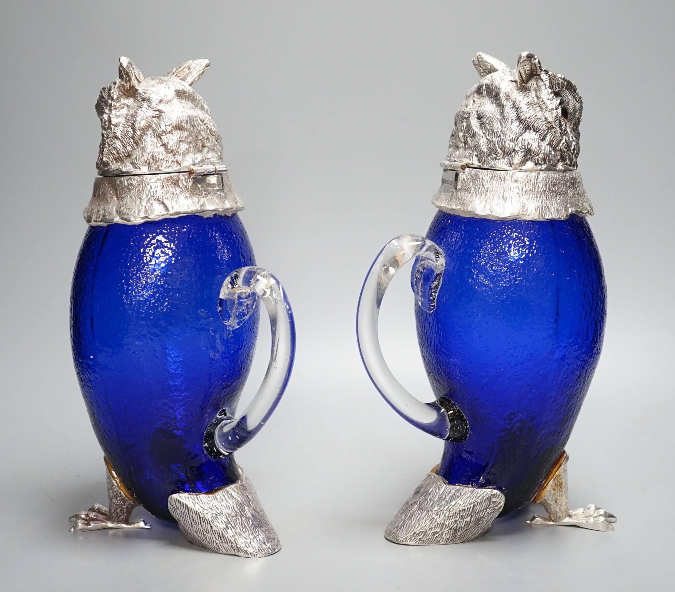 A pair of modern silver plated and blue glass novelty owl flasks, 28.5 cms high.